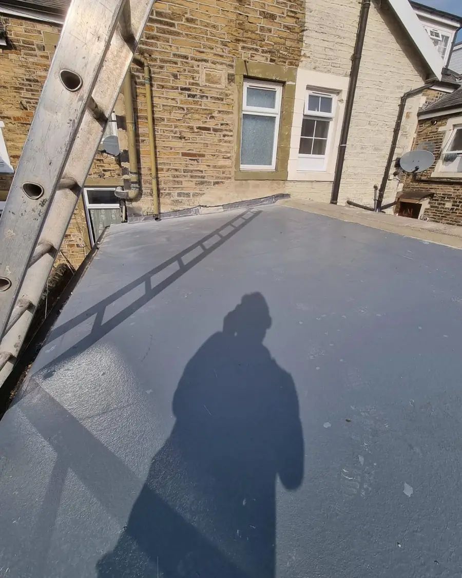 Finished flat roof with a skylight, roofer's shadow across the new covering