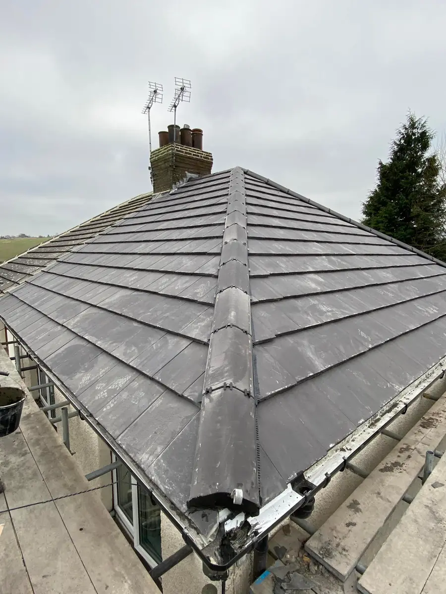 Grey tiled hip roof with dry-fixed hip and ridge