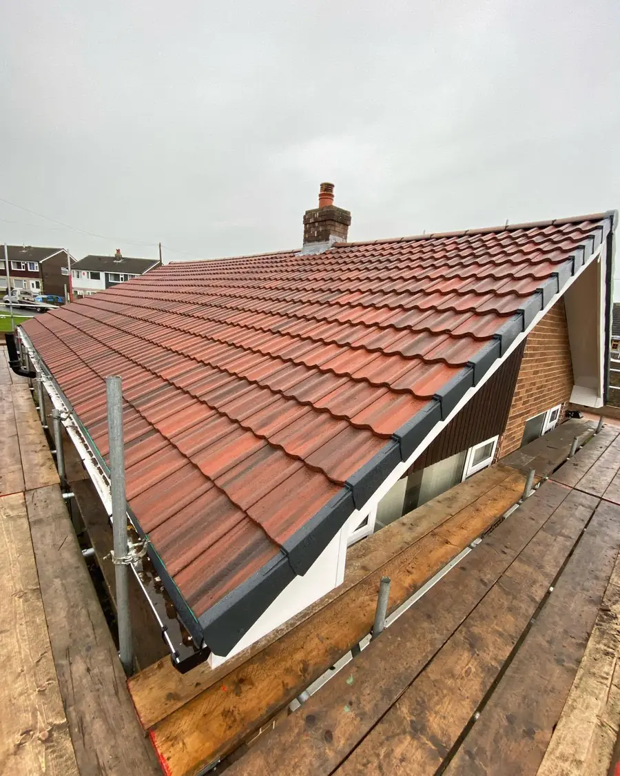 Red tiled roof on a bungalow with scaffold along the side