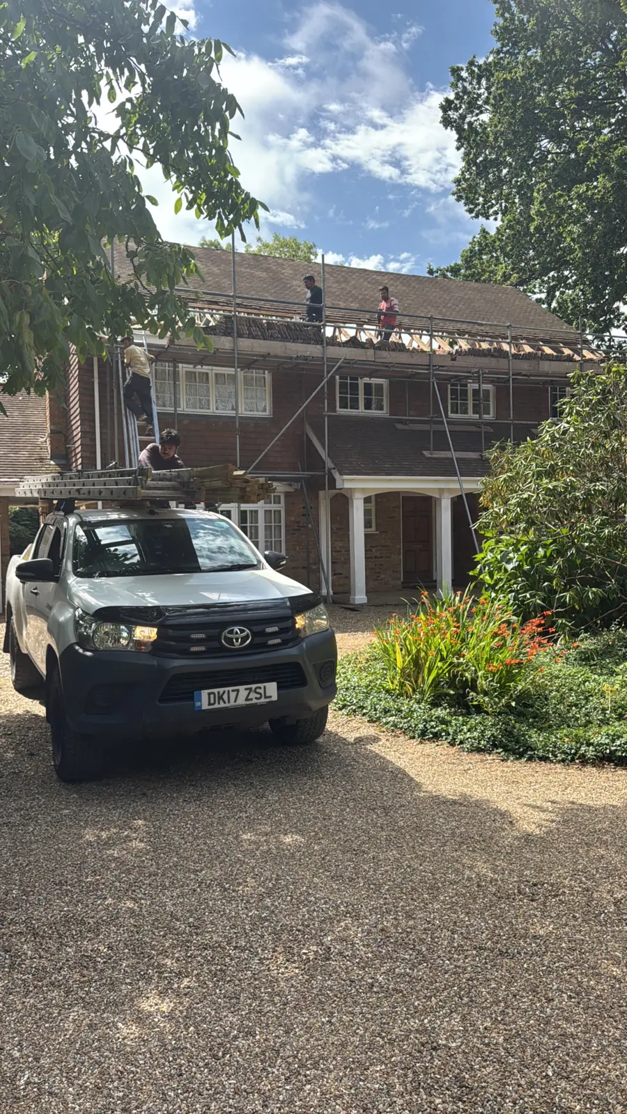 Safe Tech Roofing pickup on the drive of a detached house with scaffold up for roof work