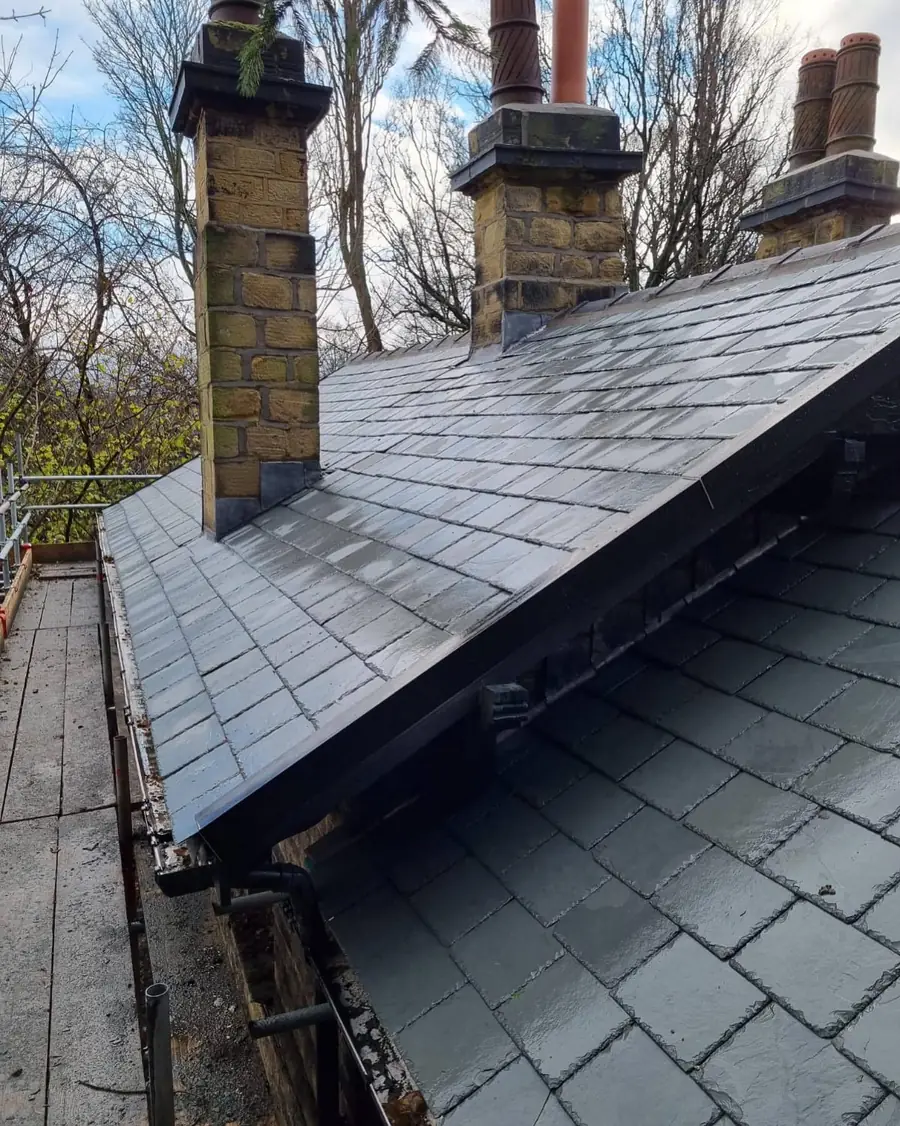 Grey slate-effect roof between two brick chimney stacks